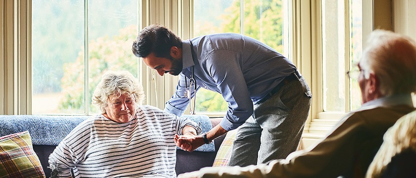 Care worker helping older lady in an adult social care setting