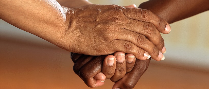 Two people holding hands, supporting one another