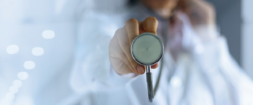 Doctor with a stethoscope in the hands on hospital background