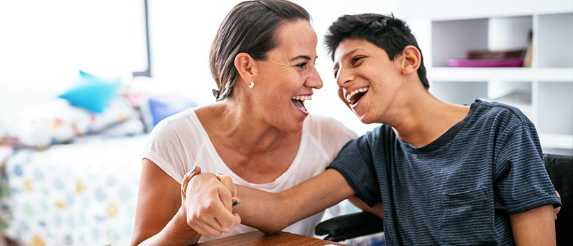 Young man with learning disability laughing with support worker