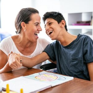 Young boy with disability laughing with carer